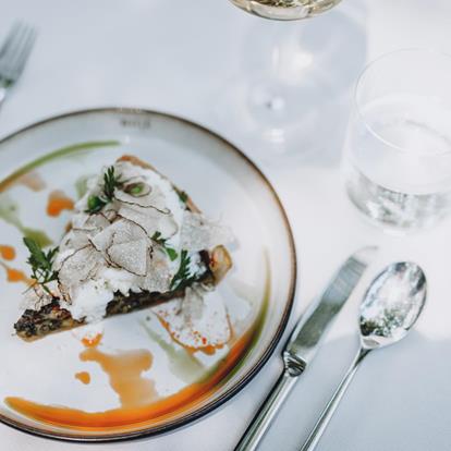 On a table there is a plate with South Tyrolean specialties, the table is set.