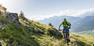 Person rides up the mountain on an e-bike during nice weather.