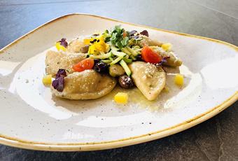 Kartoffel-Dinkelteigtaschen gefüllt mit Passeirer Bachsaibling in Kapern, Zucchini und Taggiasche Oliven geschwenkt