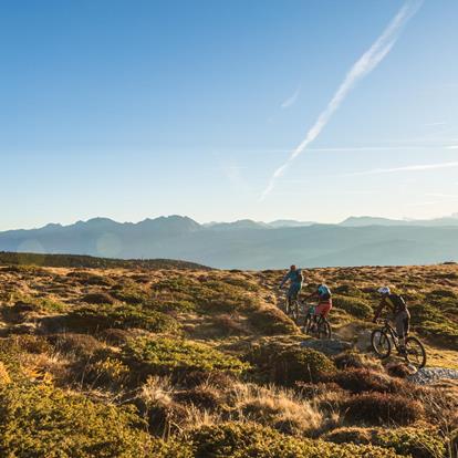 Three people ride their mountain bikes along the path at the Vigiljoch / Monte San Vigilio.