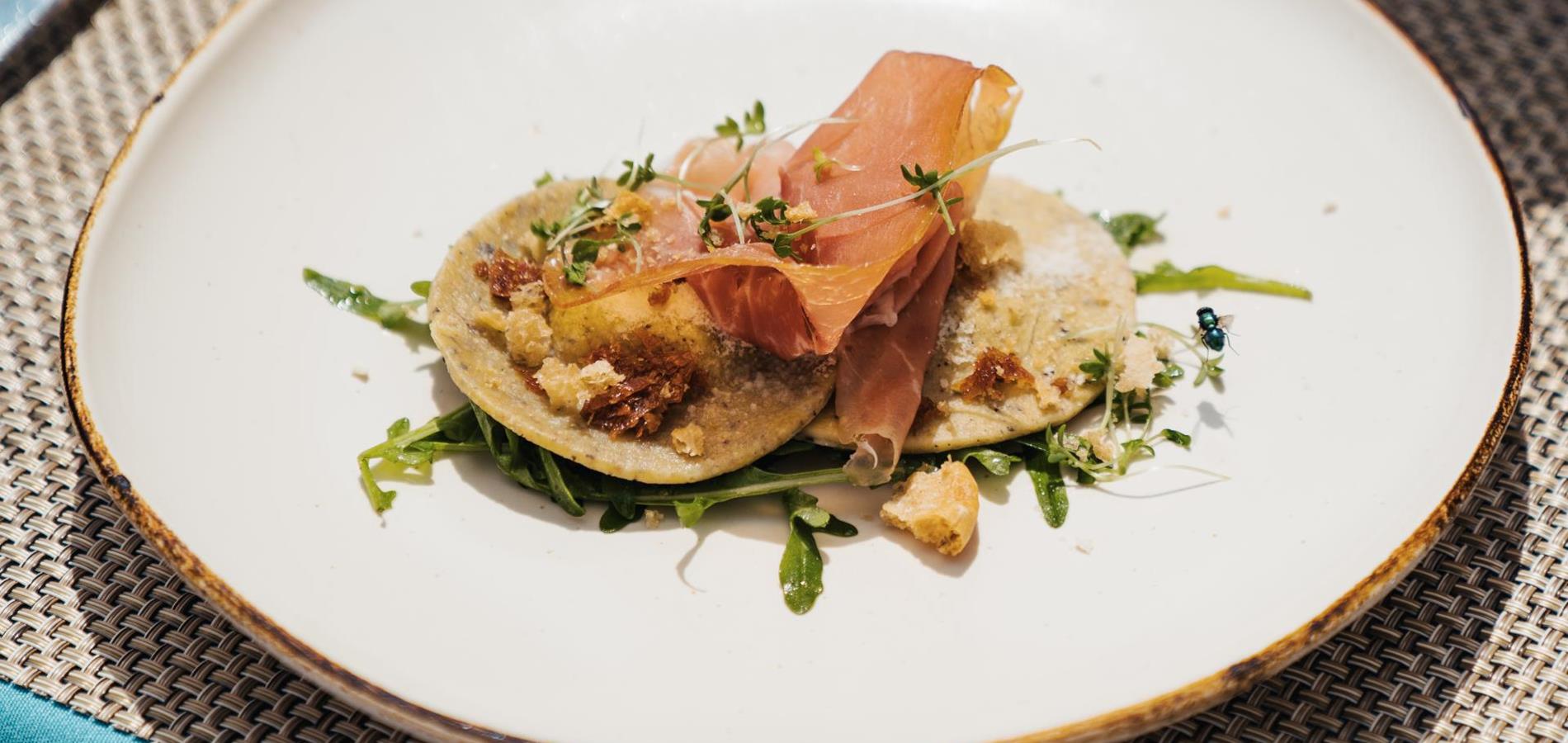 Ravioli di grano saraceno ripieni con fonduta di ricotta di bufala  Ragù di asparagi (variante pesto di rucola) / prosciutto crudo / crumble di Schüttelbrot