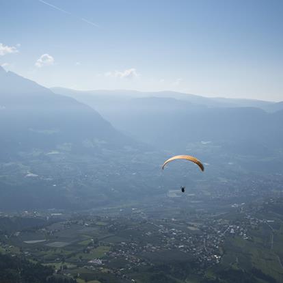 Paragleiter beim Segeln über den Ausgedehnten Weiten des Südtiroler Etschtals