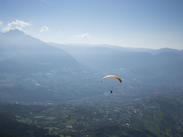 Parapendio sulle vaste distese della Valle dell'Adige in Alto Adige